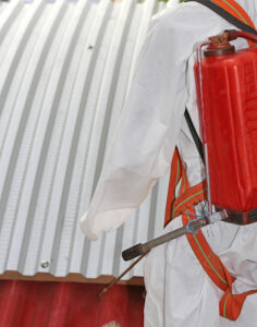 worker with protective suit during the remediation of asbestos from the roof